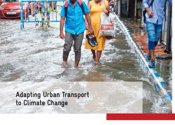 two persons walking on a flooded side walk 